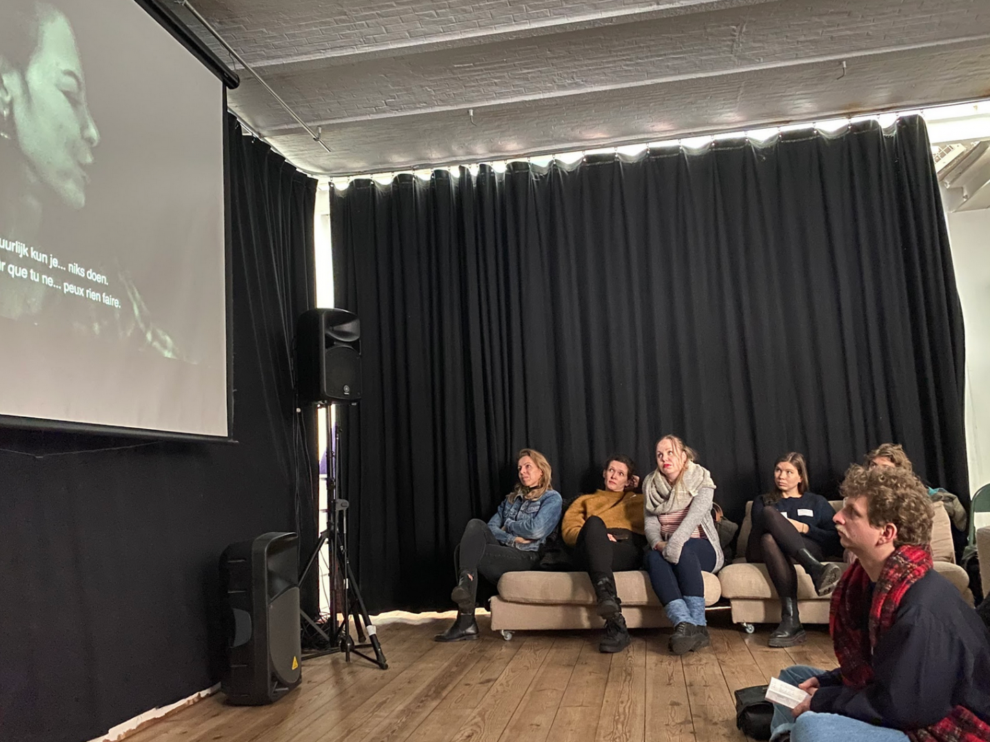 A group watching a video projection in Cinemaximilian in Brussels during Future Hospitalities.