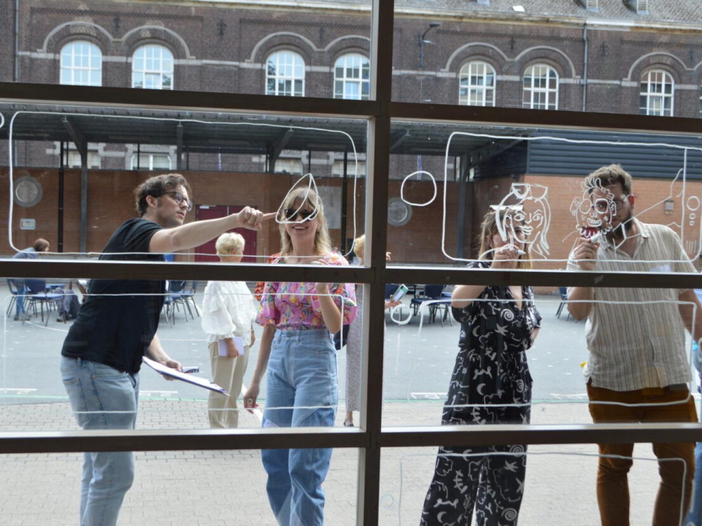 Four comic artists paint a window at a school in Charleroi