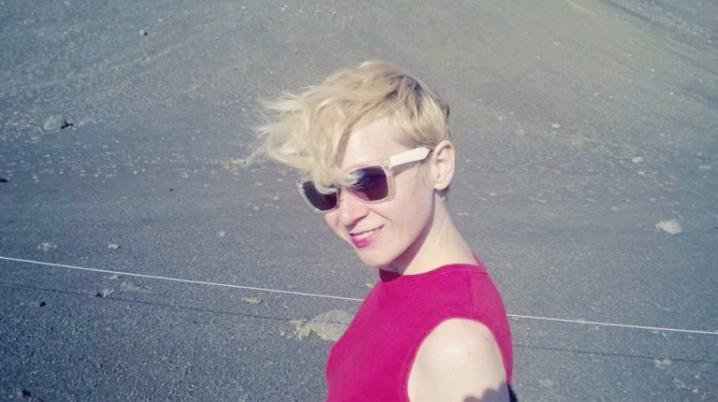 Woman with short blond hair wearing sunglasses